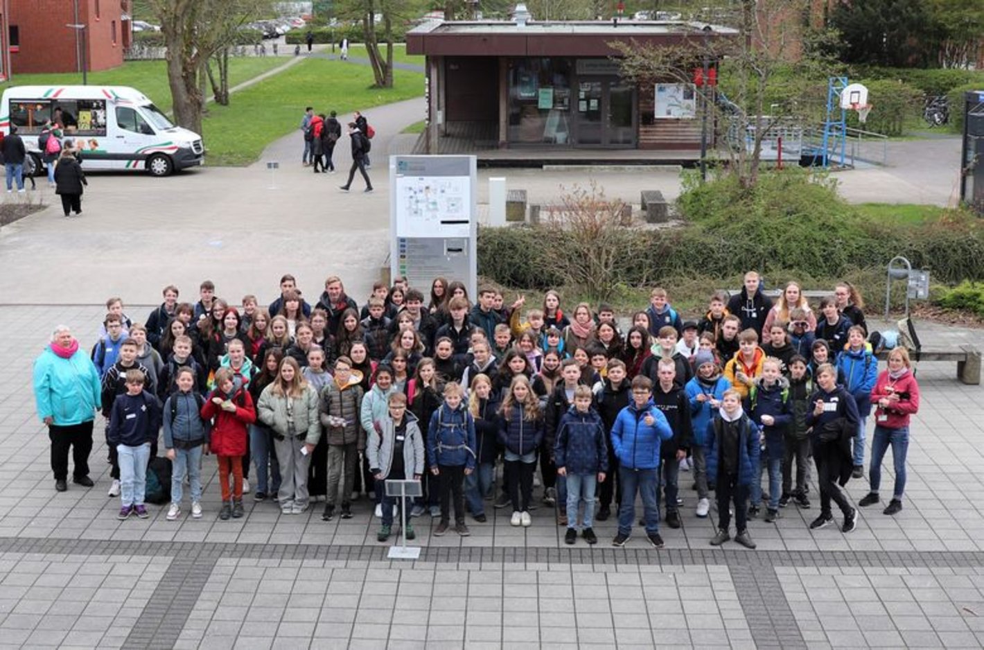 Gruppenbild vor der Mensa mit Schüler*innen