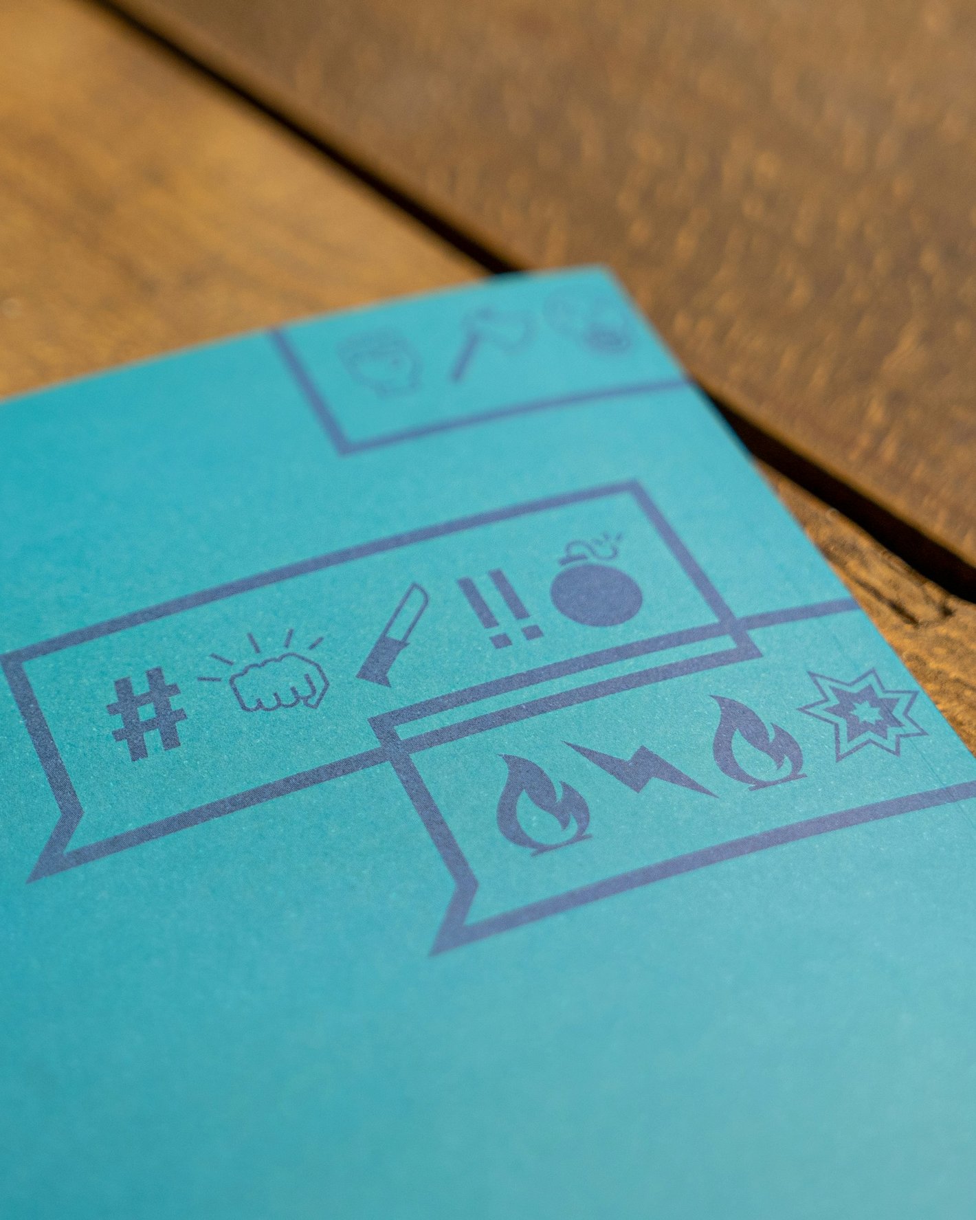 Foto eines blauen Deckblatts mit Emojis, die Hass symbolisieren