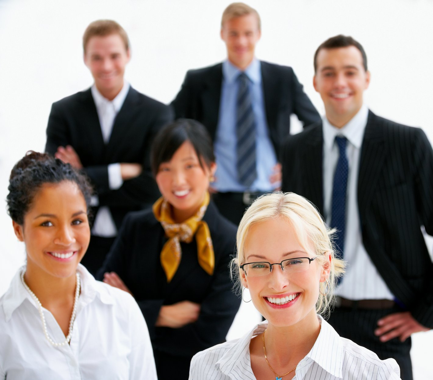 Six professionally dressed people laugh into the camera