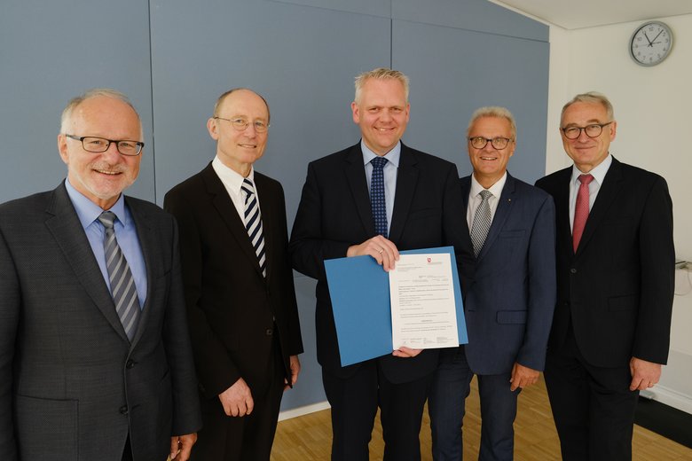 Bei der Übergabe des Förderbescheids durch Minister Björn Thümler (Mitte). Von links: Prof. Dr. Gerhard Kreutz (Präsident der Hochschule Emden/Leer), Prof. Dr. Dr. Hans Michael Piper (Präsident der Universität Oldenburg), Projektleiter Prof. Dr. Wolfgang Nebel (Universität Oldenburg) und Prof. Dr. Manfred Weisensee (Präsident der Jade-Hochschule). Foto: Universität Oldenburg/Markus Hibbeler