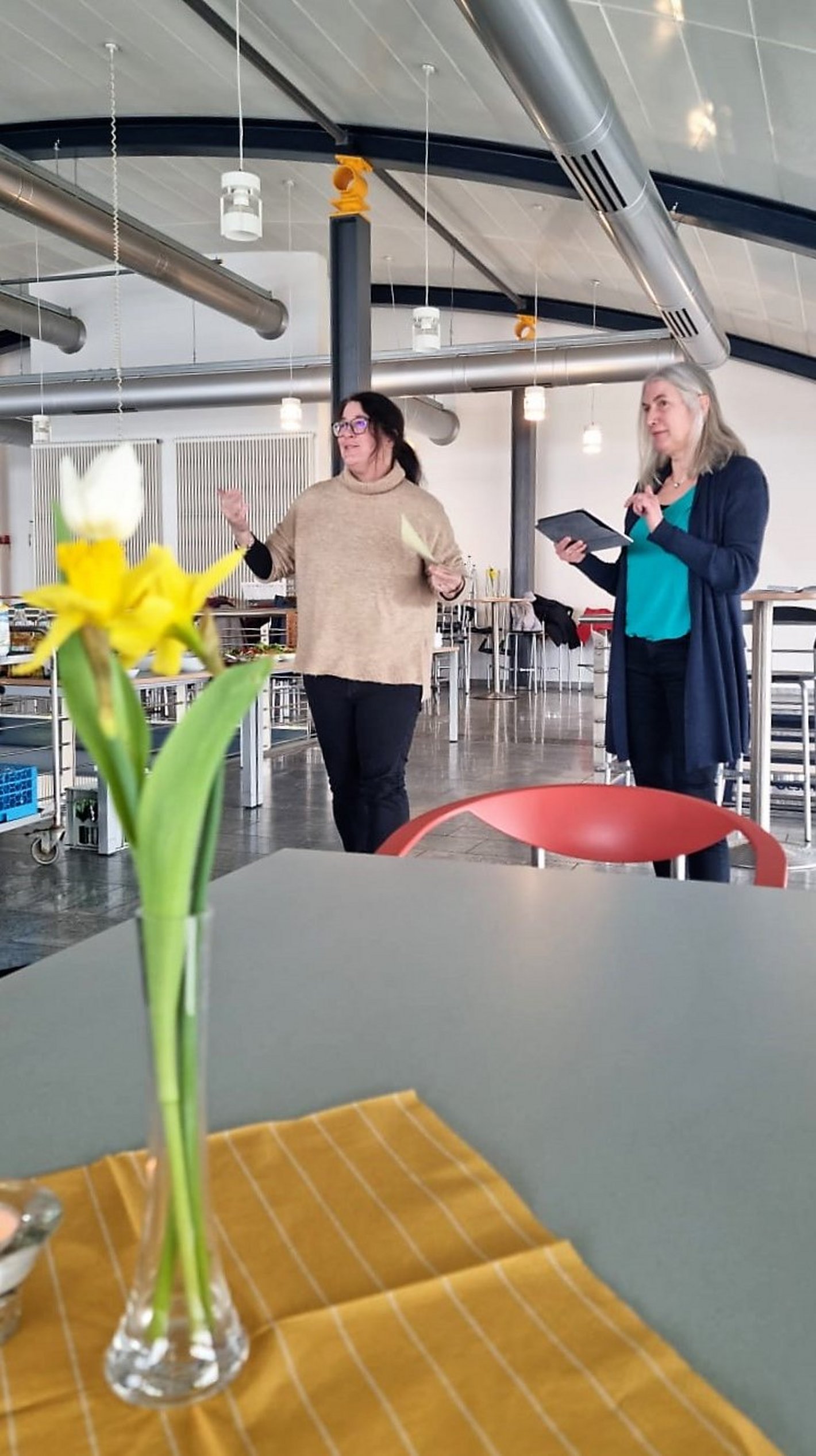 2 Personen im Hintergrund und Blume im Vordergrund - Frauenfrühstück